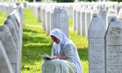 BOSNIA-SERBIA-TRIAL-GENOCIDE-WARCRIME<br>A Bosnian Muslim woman reads from a book of prayers among grave stones of her relatives who fell as victims of Srebrenica 1995 massacre, on June 8, 2021, at Srebrenica Memorial Cemetery, in Potocari. - UN judges confirmed on June 8, 2021, the genocide life sentence of former Bosnian Serb military chief Ratko Mladic over the 1995 Srebrenica massacre, Europe's worst act of bloodshed since World War II. (Photo by ELVIS BARUKCIC / AFP) (Photo by ELVIS BARUKCIC/AFP via Getty Images)