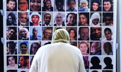 A figure in a headscarf looks at pictures of the Grenfell Tower fire victims.