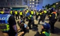 Police officers detain people after unrest in Plymouth on Monday evening.