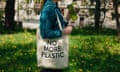 a woman holds a tote bag and a reusable water bottle