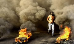 A protester runs between burning tyres in Beirut in 2012.