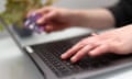 A woman using a laptop as she holds a bank card