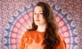 Marjolein Robertson standing in front of a wall hanging with colourful circular pattern.