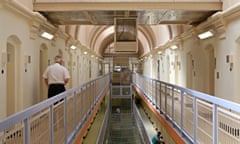 A prison officer walks down the C wing at Wandsworth prison - a Victorian prison with white calls