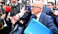 Éric Ciotti holds a blue folder as he is surrounded by members of the French press