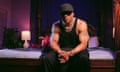 LL Cool J sitting on a bed. He has enormous muscles