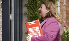 Kirsty McNeill, the Scottish Labour party candidate, standing at a voter's front door holding a red clipboard labelled: 'VOTE SCOTTISH LABOUR'