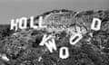 black and white photo of hollywood sign with some of the letters falling down the hill