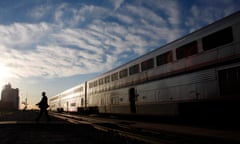 An Amtrak train attendant walks across the tracks at the Holdrege station after exiting the 5 California Zephyr Amtrak train in Holdrege, Nebraska June 13, 2008. U.S. government-owned passenger rail company Amtrak wields improper and coercive regulatory power over private freight carriers under a law that lets it help set rules that competing railroads must follow, a federal appeals court ruled on April 29, 2016. REUTERS/Joshua Lott/File Photo