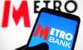 The Metro Bank logo on a smartphone with the bank logo in the background