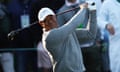 Tiger Woods winces as he takes a tee shot.