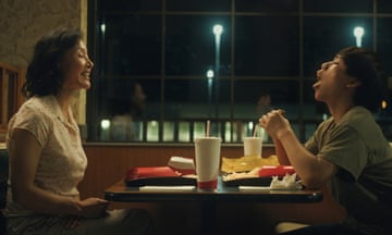 Joan Chen and Izaac Wang sitting facing each other across a table at a diner.