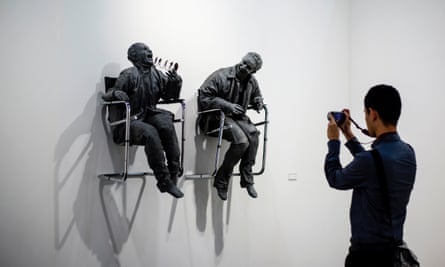 A man takes a photo of Spanish sculptor Juan Muñoz’s ‘One Laughing at the Other’ at Art Basel in Hong Kong