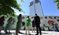 People pay their respects at the memorial for the victims of the Grenfell Tower fire on 14 June 2022.