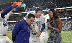 Los Angeles Dodgers designated hitter Shohei Ohtani, center, is doused by his teammates after hitting a walf-off grand slam for his 40th home run of the season at Dodger Stadium. At left is translator Will Ireton and right is Sports Net LA reporter Kirsten Watson.