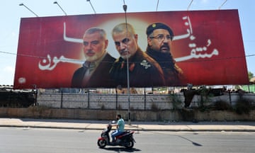 A man rides past a billboard with portraits of slain leaders, Ismail Haniyeh of Hamas, Iranian Quds Force chief Qasem Soleimani (C), and Hezbollah senior commander Fuad Shukr on the road to Beirut airport on 3 August.