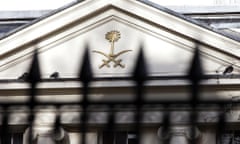 The emblem of Saudi Arabia – a palm tree above two crossed swords – on the pediment of its embassy in London, with a blurred fence in the foreground