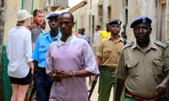 Ali Kololo, centre, is escorted by police after he was sentenced in 2013 at a court in Lamu over his alleged involvement in the murder of David Tebbutt in 2011.