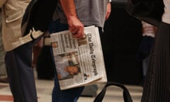 Man holding a copy of the Daily Telegraph