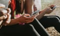 Three woman holding their mobile phones outside and looking at the screens