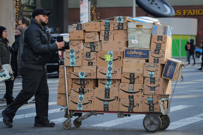 FILE PHOTO: A delivery person pushes a cart full of Amazon boxes in New York City, U.S., February 14, 2019. REUTERS/Brendan McDermid/File Photo