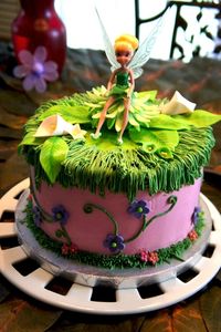 This is a fairy cake for a fairy themed birthday party for a 5 year old girl.   It is filled and covered in SMBC, with American buttercream piping and MMF flowers/leaves.  The inside is pink and purple!