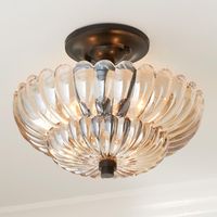 This gorgeous ceiling light features a stunning scalloped shade of a beautiful amber glass paired with hardware finished in a rich mottled bronze perfect for adding glamour to rustic spaces and refined elegance to modern and contemporary spaces.