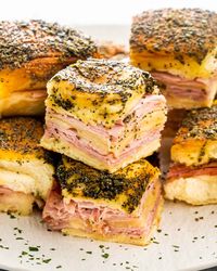 These Ham and Cheese Sliders are made with Hawaiian sweet rolls loaded with Swiss cheese and sliced ham, topped with a delicious poppy seed and mustard melted butter and finally baked to a yummy perfection. Incredibly easy, quick and a total crowd pleaser. #hamandcheese #sliders #recipe