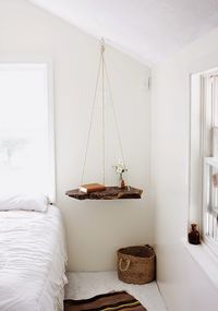 A floating bedside table creates an illusion of more space and gives the room a touch of the wood element.