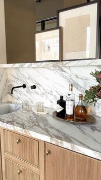 Marie Flanigan Interiors on Instagram: "A beautiful bar crafted with ribbed white oak mill work, a brass mirror backsplash and Calacatta Oro Marble at our #Tanglewood project. #interiordesign #bar #customhome #luxuryhome"