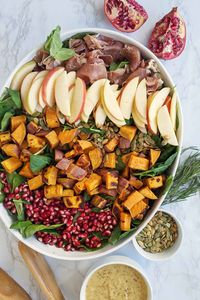 This healthy Fall Cobb Salad is packed with the fun flavors and textures of the season. The salad is finished off with a homemade rosemary and apple cider vinegar fall salad dressing. The salad is packed with apples, sweet potatoes, pomegranates, and more! This would be the perfect Thanksgiving side salad dish (you could even make it ahead of time). It will definitely feed a crowd for a party or holiday get together!