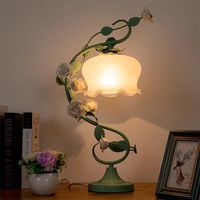 This creative table lamp features a high-quality glass shade with good light transmission and a patterned shade mouth to show a sense of three-dimensionality; the iron material is pressed into the shape of a rose leaf wrapped around the lamp post and embellished with several ceramic white roses, symbolizing romance and beauty.Perfect for installation above the bed as a night light, or on a coffee table, study or home office, etc. Voltage 110V-120V/ 220V-240V Material Glass,Iron，Ceramic Light Fix