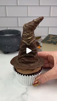 Rachel Lindsay on Instagram: "The sorting hat 🧙🏼‍♀️🪄

Lift them up to see what house you’re in ♥️💙💛💚

How to turn an🍦cone into the sorting hat. 
🪄 Cut the point off an ice cream cone, stick it the opposite way with some melted chocolate. 
🪄 Dip the end into the melted chocolate.
🪄 Sit it onto parchment paper and pour over melted chocolate. Use a toothpick to help guide the chocolate, making a brim around the bottom. 
🪄 I used a thin decorating brush and melted chocolate to add some texture to the hat. 
🪄 Add a colourful swirl of buttercream to your cupcakes.
🪄 Fill the cones with coloured candy. 
🪄 Sit the cupcake onto the hat and carefully flip them over. 

#cupcake #harrypotter #thesortinghat #easyideas #halloweenbaking #cakedbyrach #chocolate #cutefood #cakeart #cupcakesof