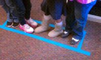 Have the students line up from shortest to tallest, shoulder to shoulder, facing the same direction. make a rectangle on the floor around them so that they have very little room around them. Then they have to reverse the line from the tallest to the shortest without stepping outside the lines.  ask them to imagine that they are surrounded by alligators and lava.  If they step out, they start over. add challenges by taking away verbal communication, take away their eye sight.