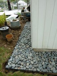 A rock maintenance strip around the house ... catches splashes, keeps walls clean and minimizes pests. Put your foundation plantings in front of the strip.