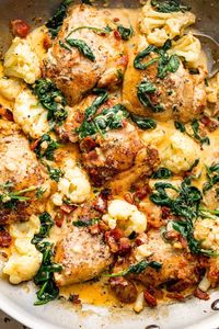 Creamy Chicken and Cauliflower is a delicious dinner with chicken thighs, diced bacon, spinach, and cauliflower cooked in a Parmesan sauce.