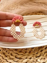 Hand made polymer clay earrings with a coral flower and checkered arch