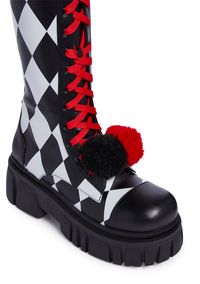 keep 'em entertained. These calf-high clown boots have a vegan leather construction with a diamond print all over, chunky platform soles, contrast adjustable lace-ups with double pom pom details, and side zip closures.