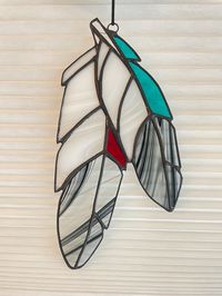 Brand new Two Feather stained glass design! These one of a kind eagle feathers are made using a special black and clear Spectrum glass that is discontinued and now quite rare (it's also my faviourite!). It is combined with white and clear glass, red glass and textured turquoise glass for a classic Copper & Came feather reboot.   One of a kind and ready to ship! This is the perfect gift for that hard-to-buy-for-person in your life! This stained glass decorative art piece will shine beautifully in