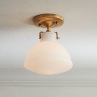 A semi-flushmount ceiling light that's perfect for living rooms, bedrooms, closet spaces, hallways, and more. This fixture comes in a gold finish frame, which supports a shapely opal glass shade that hangs from the bottom. Add Mid-Century Modern lighting to your home with this lovely ceiling light design.