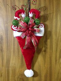 For those who think outside the box, this is a different take on the traditional Santa Hat. This plush hat is filled with assorted Christmas picks, elf legs and a wired ribbon bow. May vary slightly from picture. A perfect way to greet your guests and brighten the holidays A loop on