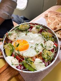 Mexican chicken casserole topped with a fried egg, avocado, salsa and Mexican cheese in a mini casserole dish.