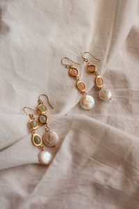 Radiate with the glow of sun-kissed shores with these enchanting Sunstone and Prehnite dangle earrings, artistically adorned with a freshwater pearl at the bottom. This pair of earrings embodies the vibrant hues of a sunny beach day and the mystical allure of the sea. The warmth of the gemstones, paired with the coolness of the freshwater pearl, creates the perfect balance.  All earrings are madew using Gold-Filled earwire. Gold-filled pieces are stunning jewels that are second to pure gold. The