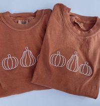 Embroidered Pumpkin T-Shirt -Embroidered on 100% Cotton, Comfort Colors Brand T-shirts. This design is simple and minimalistic, perfect for every outfit! -Embroidery design measures 5"x 1.5" -See product pictures for shirt sizing chart. These t-shirts run true to size, so if you like an oversized look, we recommend sizing up 1 size! -All t-shirt designs are handmade on an embroidery machine so there may be slight differences, but we only sell the shirts that meet our high-quality standards. -To