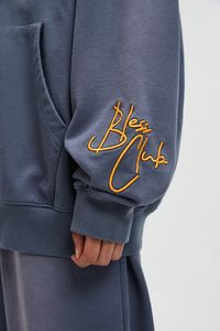 Description: Experience the urban vibe with the Slogan Logo Washed Hoodie, where street art meets sophistication. The front boasts a graffiti-infused LOGO and slogan, while a refined embroidery slogan graces the left cuff, offering a unique blend of contrasts. Its washed gradient coloration lends a vintage aesthetic, beautifully complemented by the premium 445gsm heavyweight 100% cotton fabric. Styled in a slightly oversized silhouette, it's where comfort meets fashion. Graffiti-styled front LOG