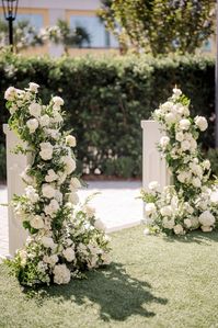 A beautiful garden party ceremony set-up at the Four Seasons in New Orleans.  We used white pedestals overflowing with neutral florals and trailing greens to accent their gorgeous courtyard.