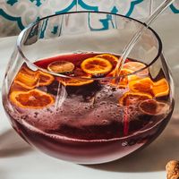 1 qt chilled pomegranate juice 2 Tbsp fresh lime juice 1/4 cup superfine granulated sugar 2 (750ml) bottles chilled Prosecco 2 clementines, thinly sliced crosswise 1 lime, thinly sliced crosswise