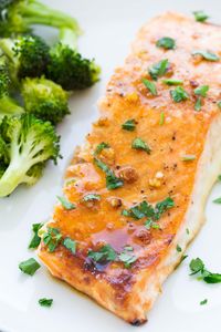 This easy oven baked salmon recipe is our favorite! The salmon is cooked in a honey, Dijon and garlic glaze and takes just 10 minutes of prep time. This delicious salmon recipe is perfect for a fancy dinner or weeknight meal!