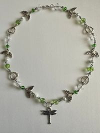 This is a green and pearl dragonfly bead necklace made from hand. The necklace contains a variety of green beads as well as pearls, heart, and dragonfly's. This necklace is about 21 inches longs and a perfect gift for anyone who loves necklaces and/or dragonfly's.