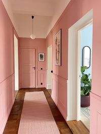 Dusty pink hallway in Swedish apartment, with colour blocked door